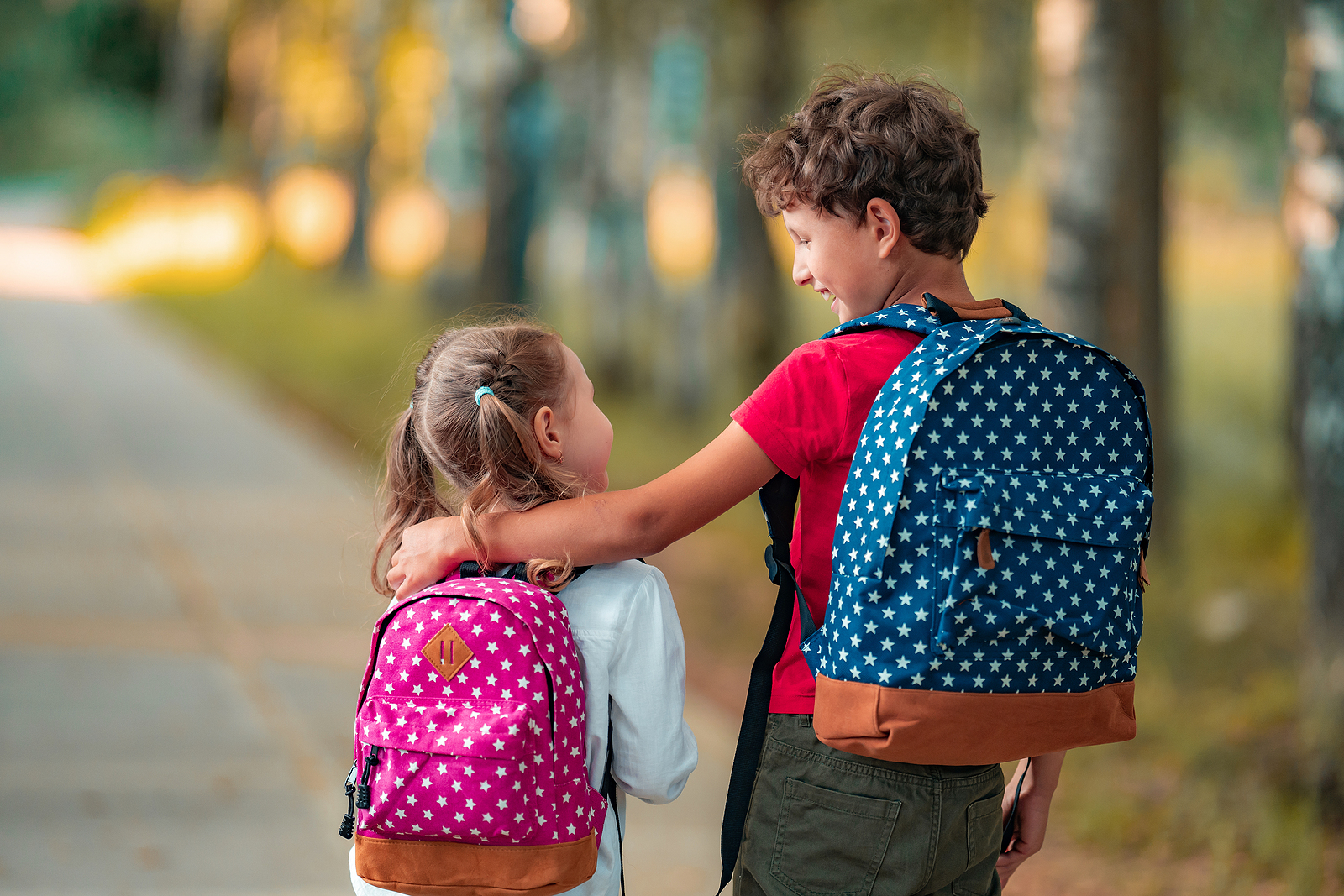 Primary School Pupil. Boy And Girl With Backpacks Walking Down S